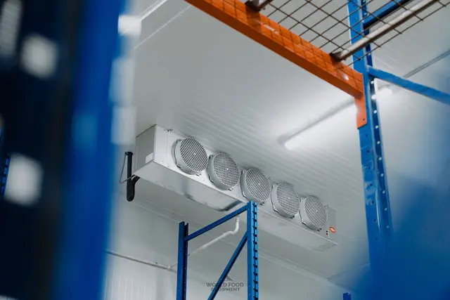 Evaporator mounted above pallet racking in a cold room