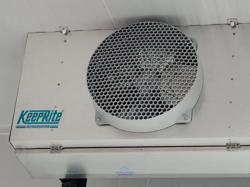 Close-up of a KeepRite Refrigeration single-fan ceiling-mounted evaporator at the halal meat processor in Mississauga, KeepRite Refrigeration logo prominent on the unit casing, white insulated panel ceiling above.