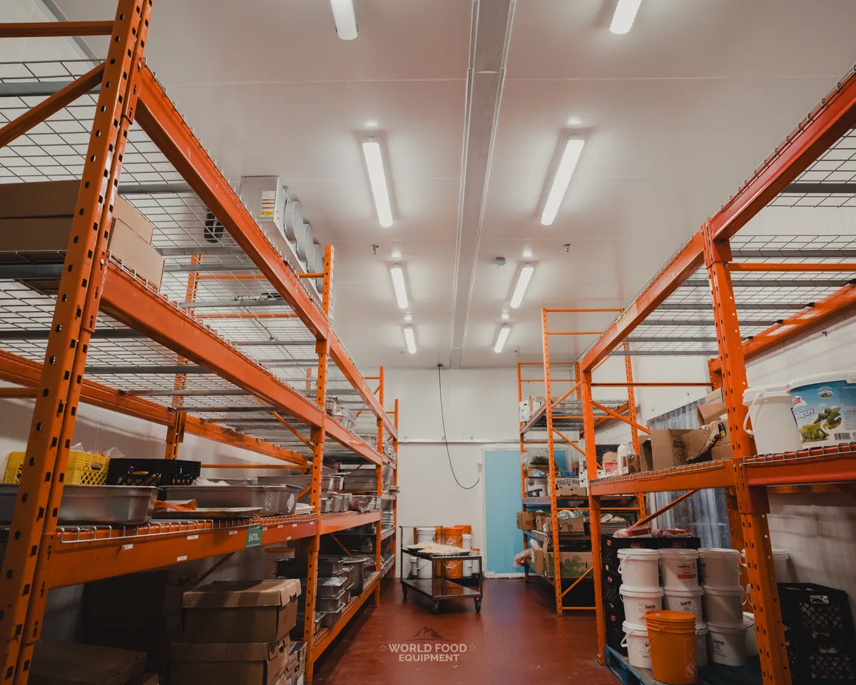 Trenton three-fan evaporator ceiling-mounted in a finished Ontario walk-in freezer, condensate drain fitting on the underside, white insulated panel walls and ceiling, Stainless Steel project by World Food Equipment